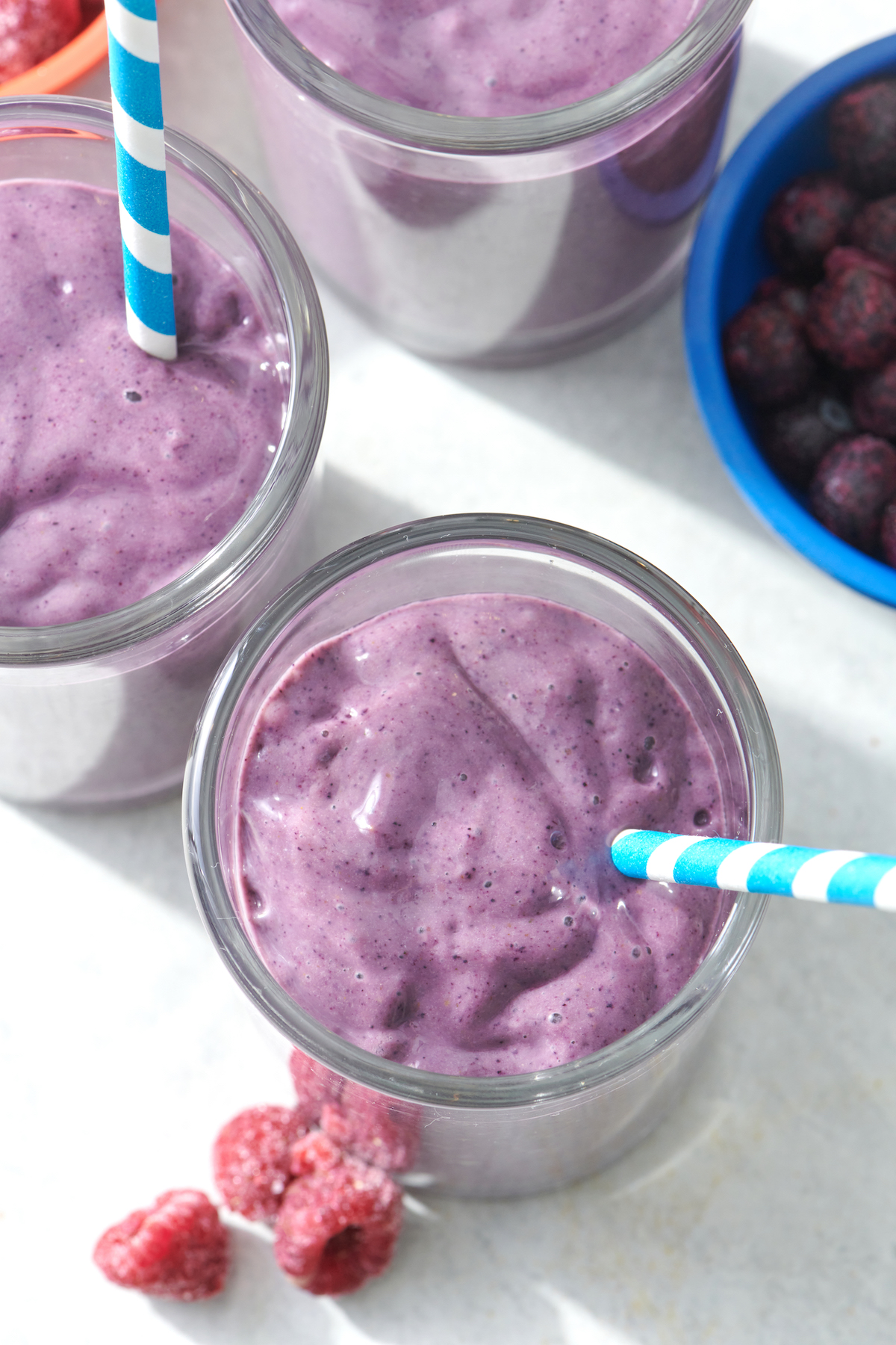 Brain Boosting Smoothie in clear glass with blue striped straw.