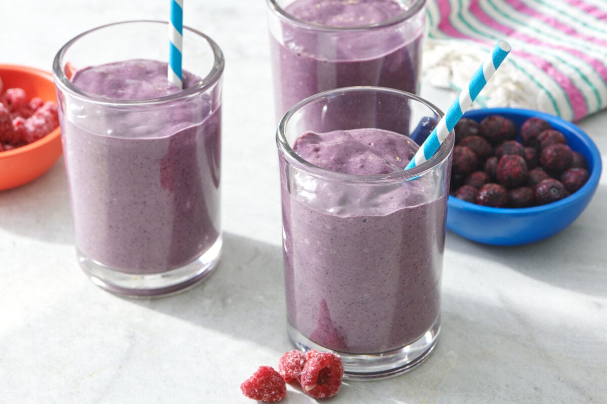 Brain Boosting Smoothie in clear glass with blue striped straw.