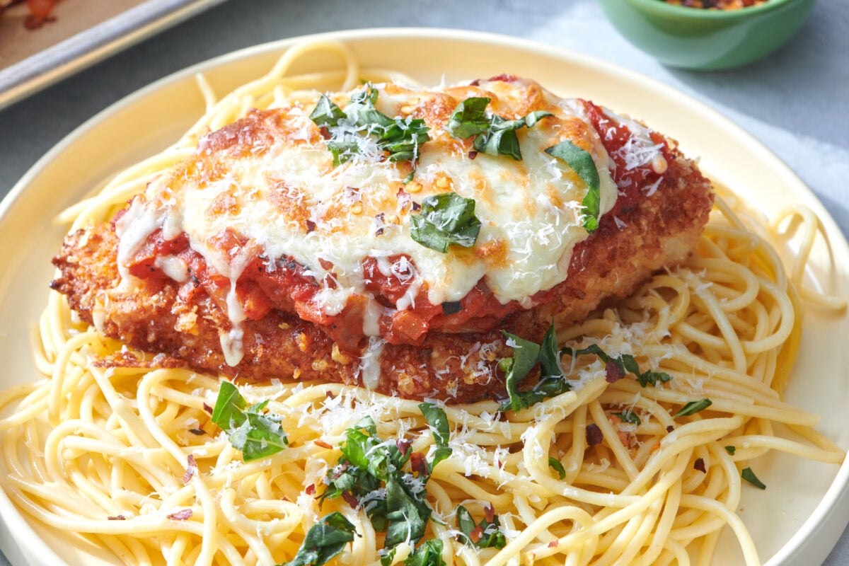 Crispy Chicken Parmesan on bed of spaghetti noodles.