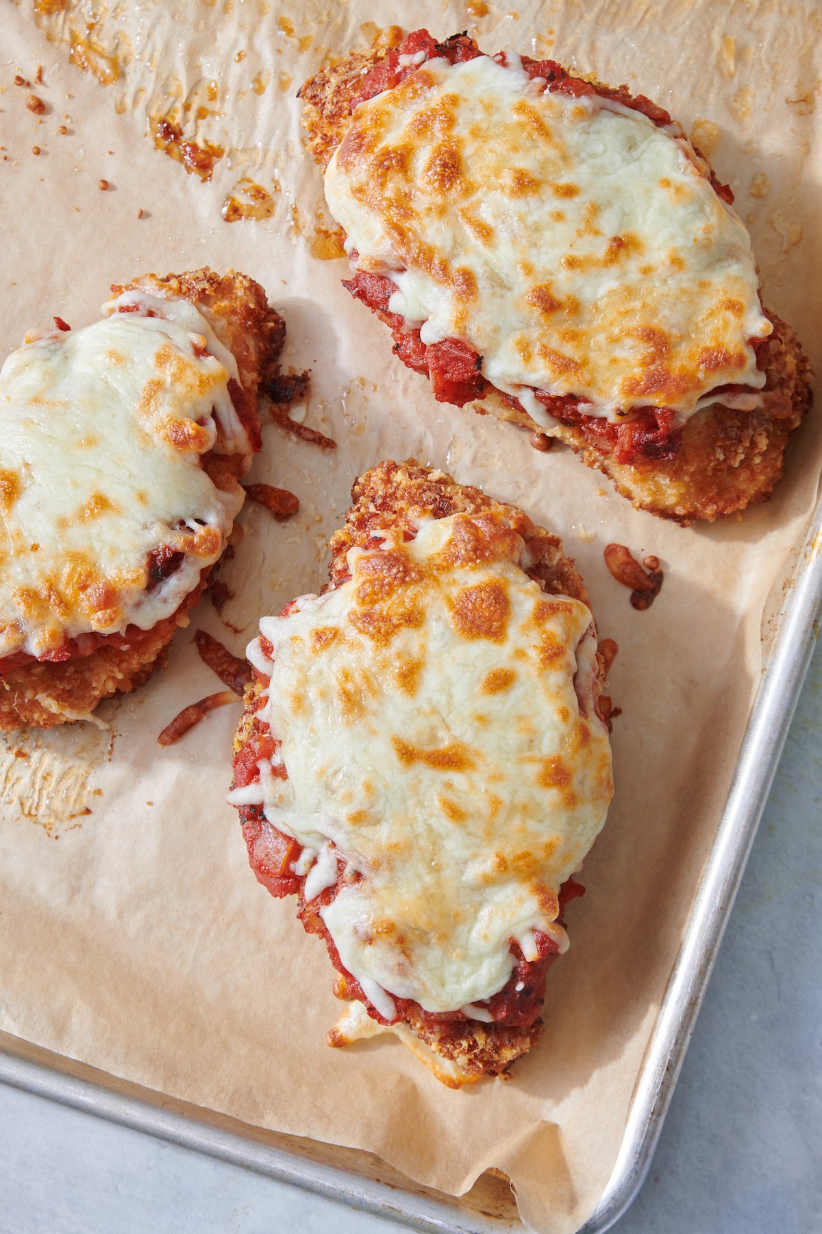 Chicken parmesan on baking sheet.