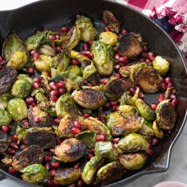 Brussels sprouts and pomegranate seeds in cast iron skillet.