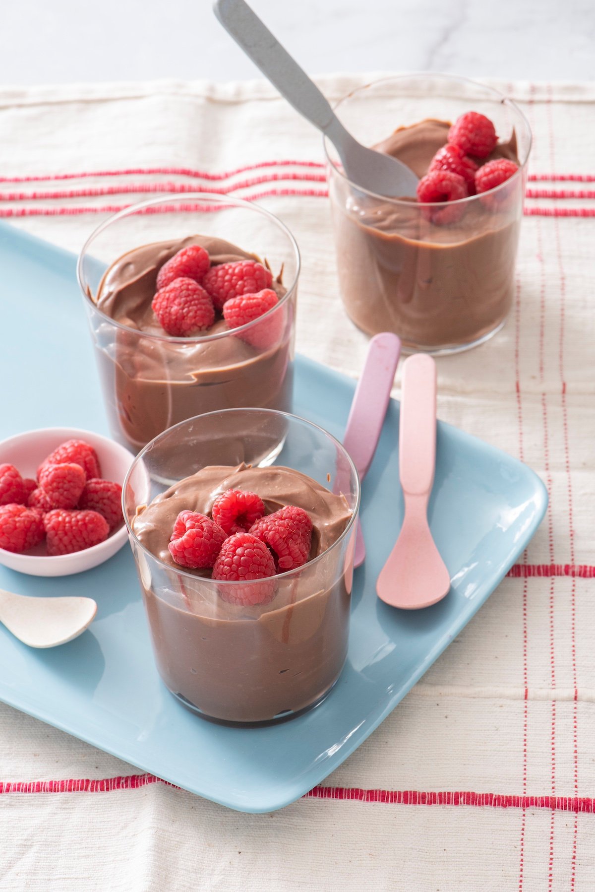 Chocolate Tofu Pudding in clear glasses topped with raspberries.