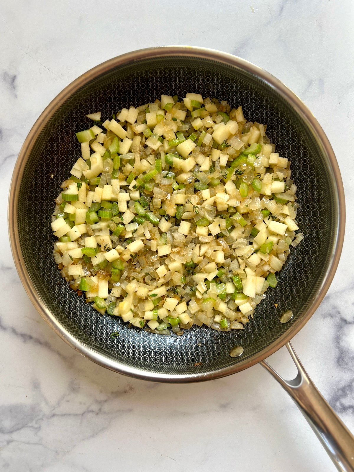 Onion and celery in a skillet.