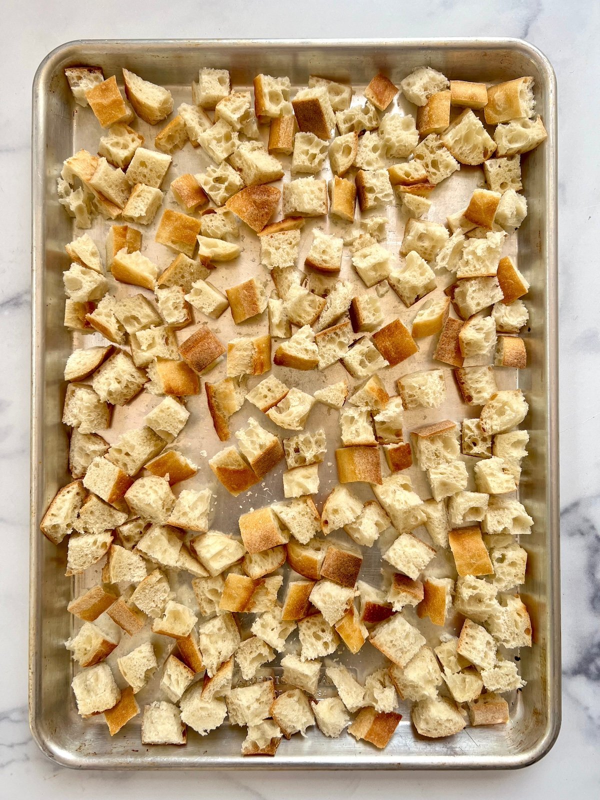 Bread cubes on a baking sheet.