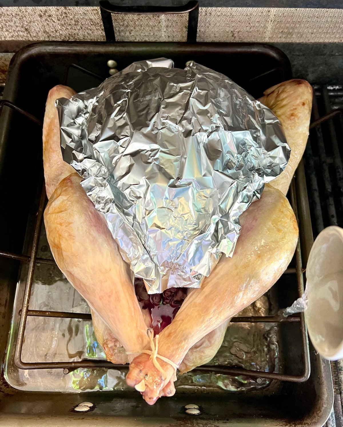 Covering turkey breast with foil.