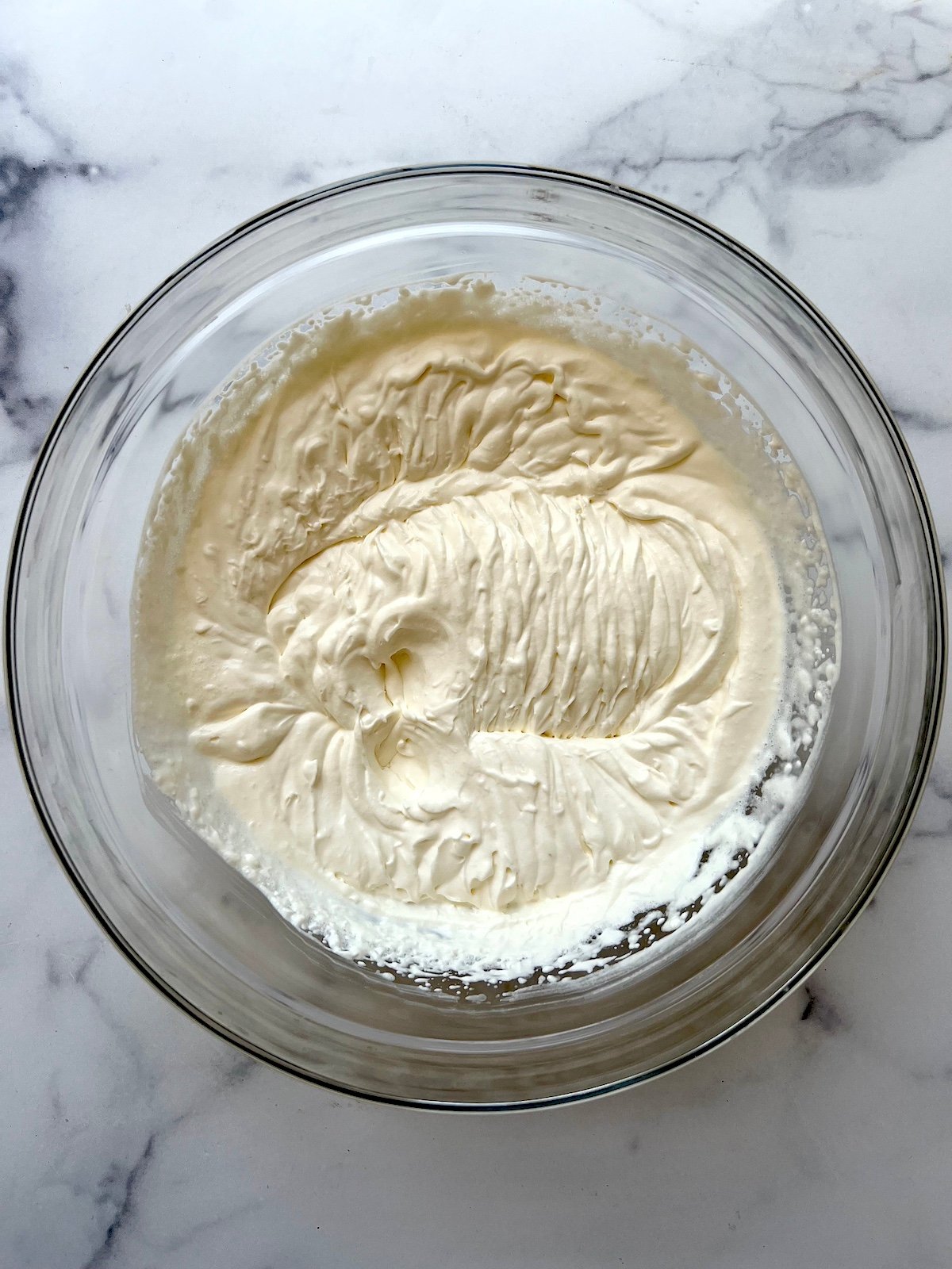 Homemade whipped cream in a mixing bowl.