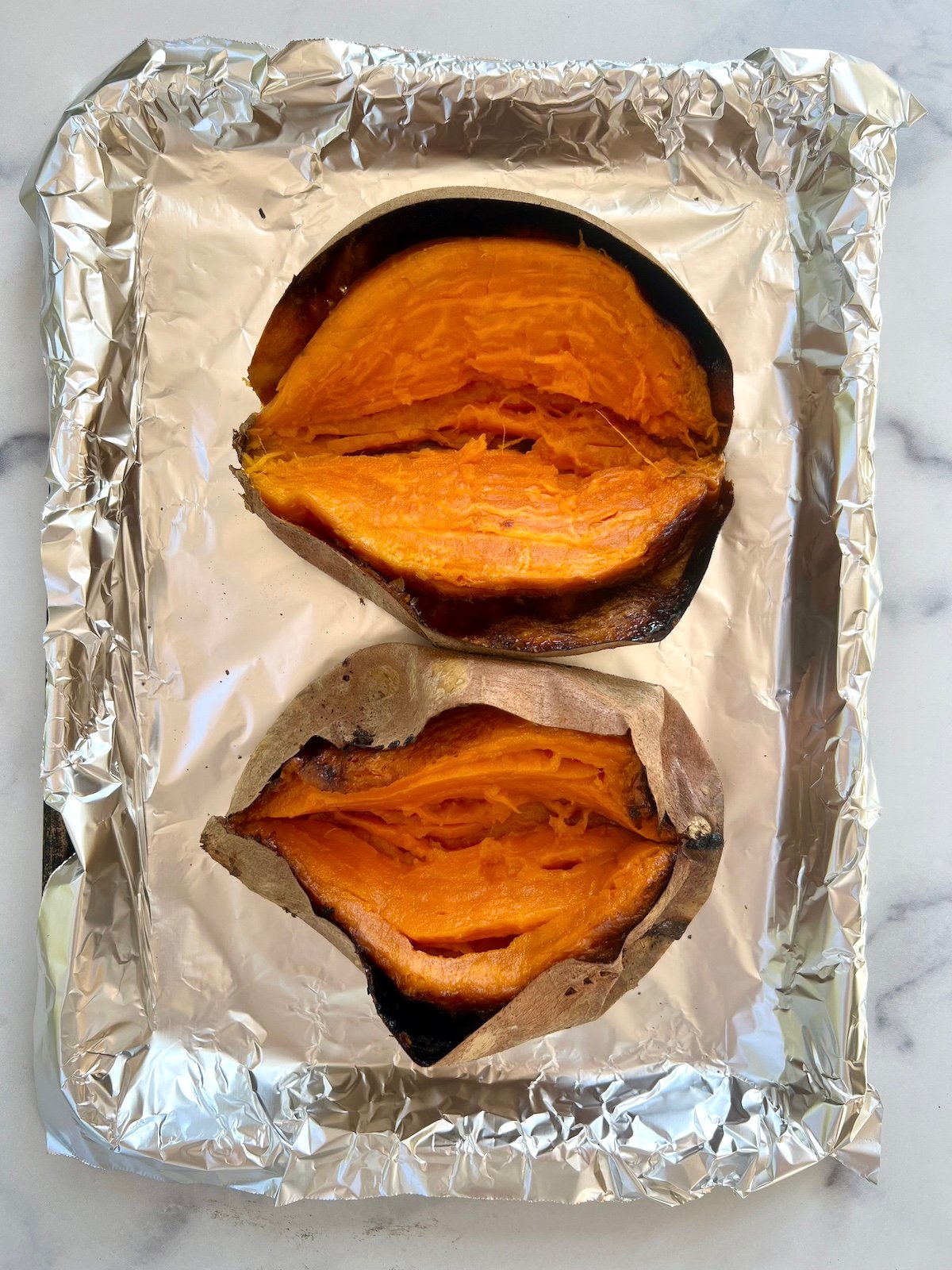 Baked sweet potatoes split in half.