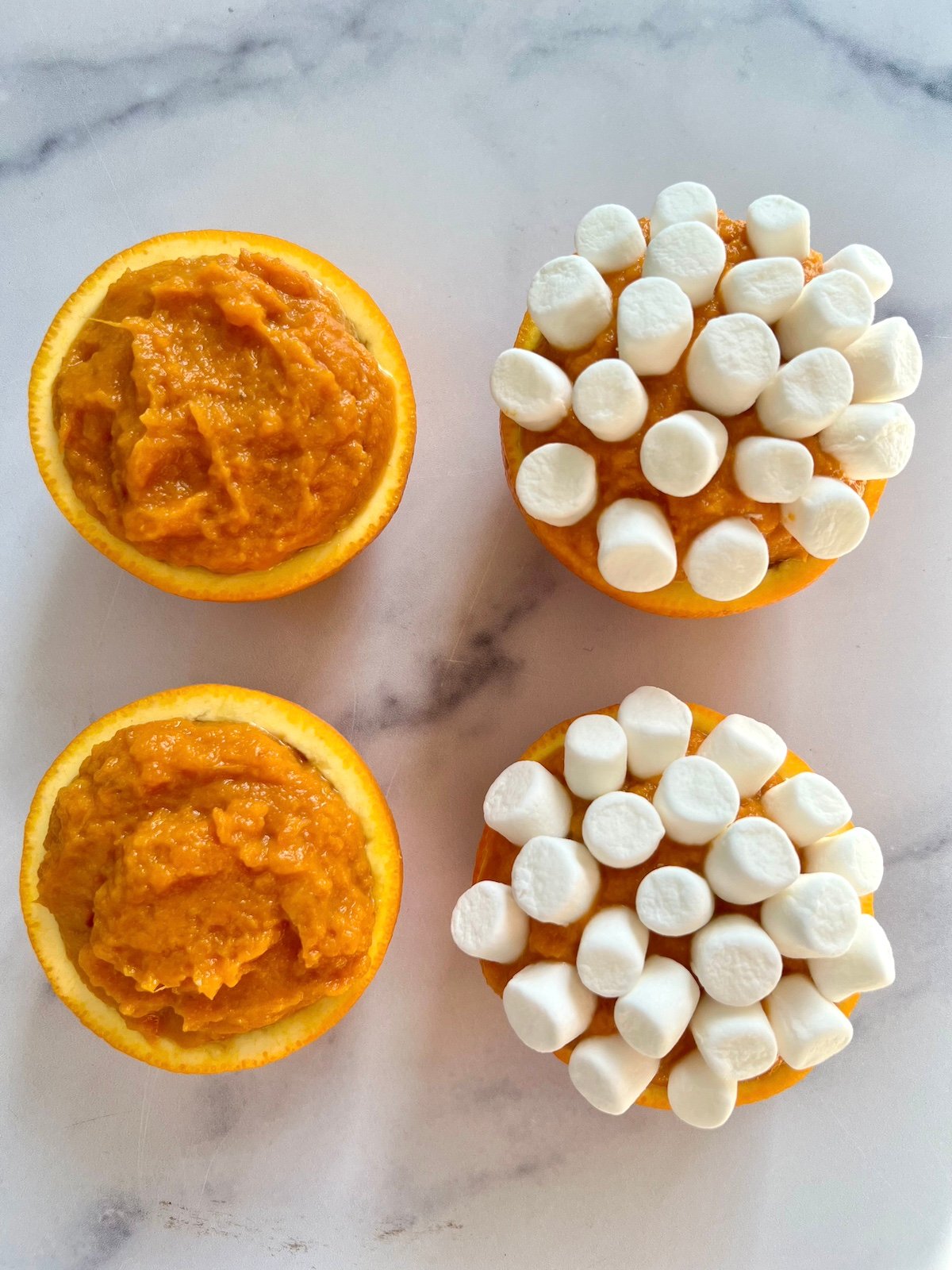 Sweet potato casserole in orange cups topped with marshmallows.