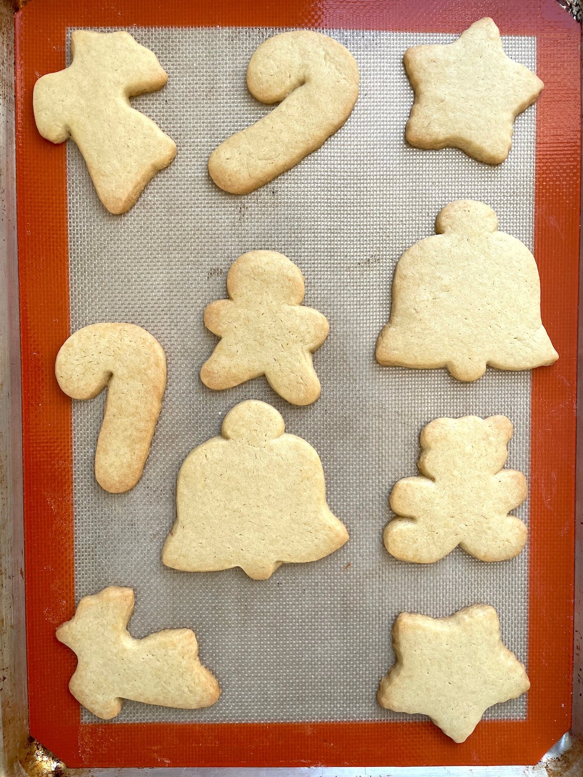 Baked sugar cookies on baking sheet.