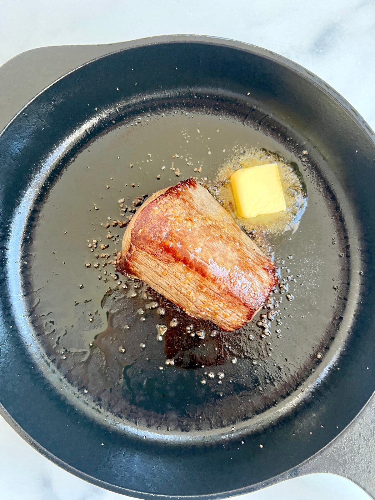 Tablespoon of butter in skillet for basting steak.