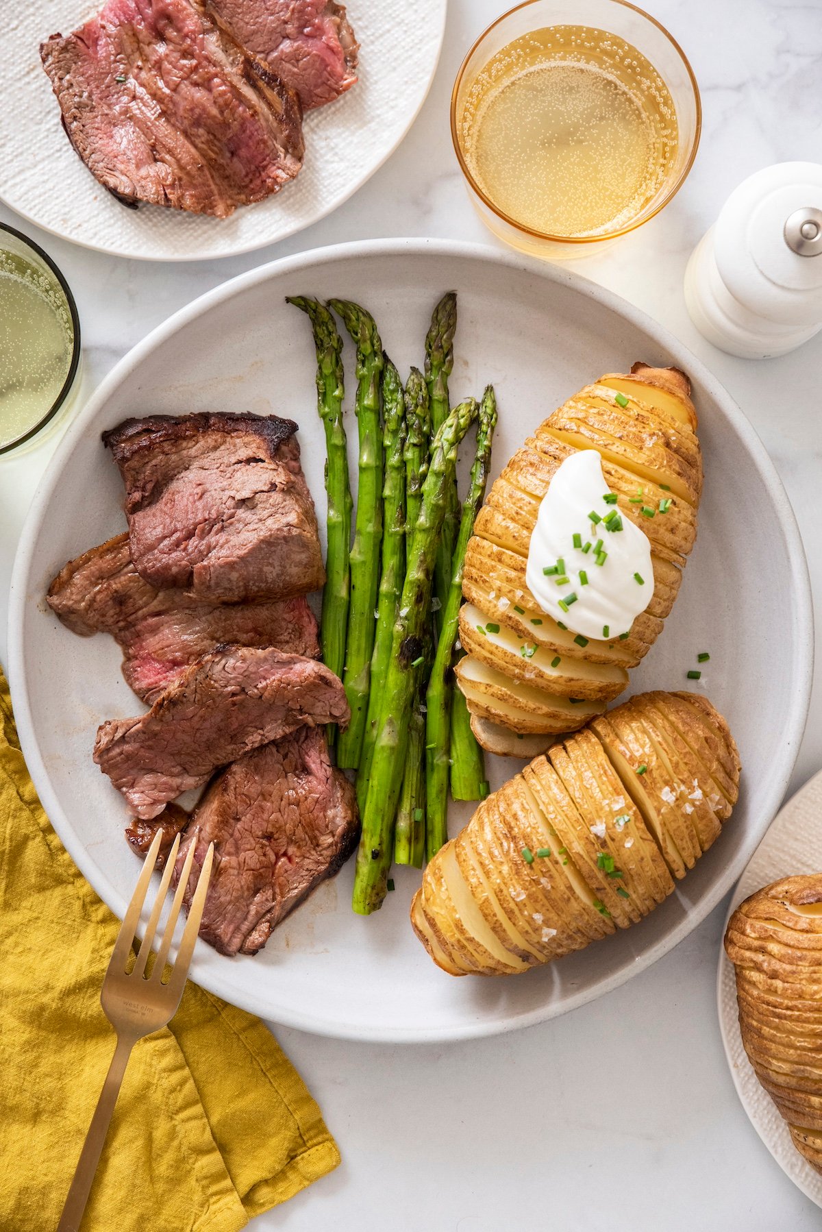 Pan seared beef tenderloin on plate served with asparagus and potato.