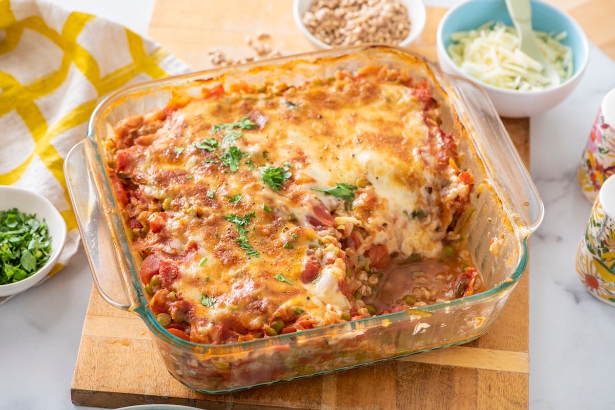 Baked farro with lentils, tomato and mozzarella in baking dish.