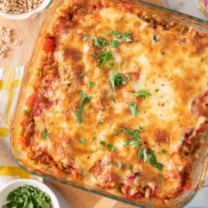 Baked farro with lentils, tomato and mozzarella in a baking dish.