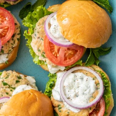 Middle Eastern Chicken Burgers topped with cucumber yogurt sauce.