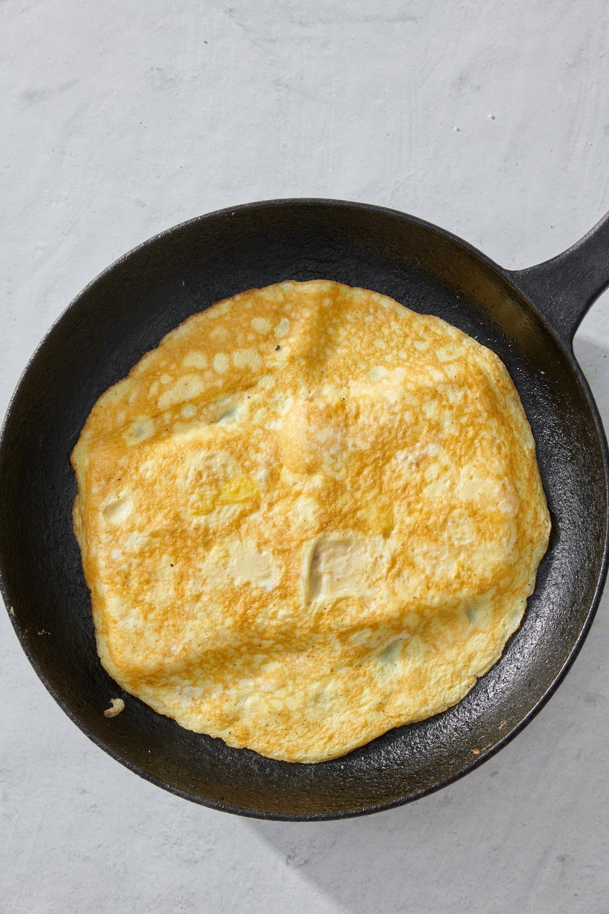 Cooked eggs in a skillet on top of sandwich bread.