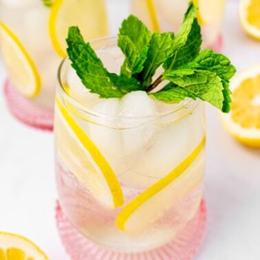 Lemon mint tea in a glass over ice.