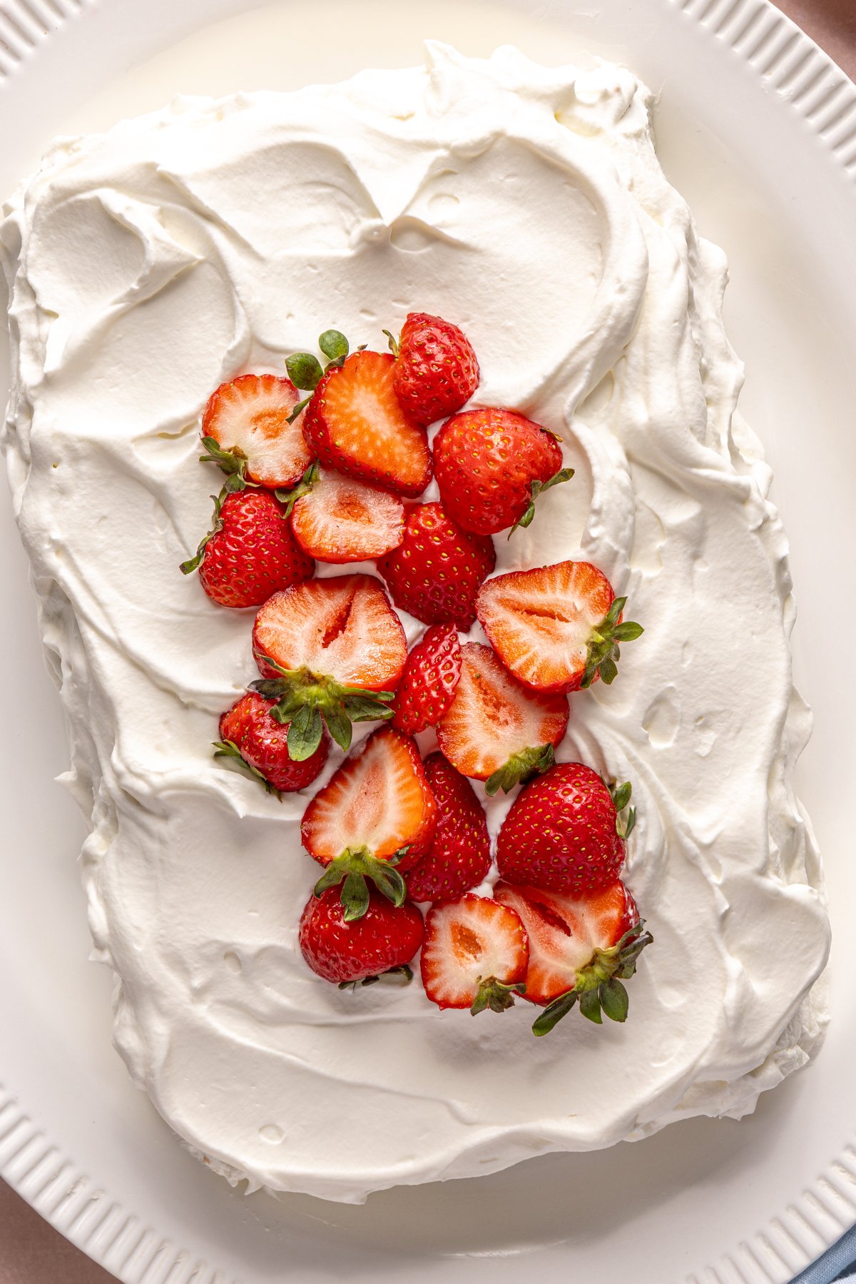 Tres leches cake topped with sliced strawberries.
