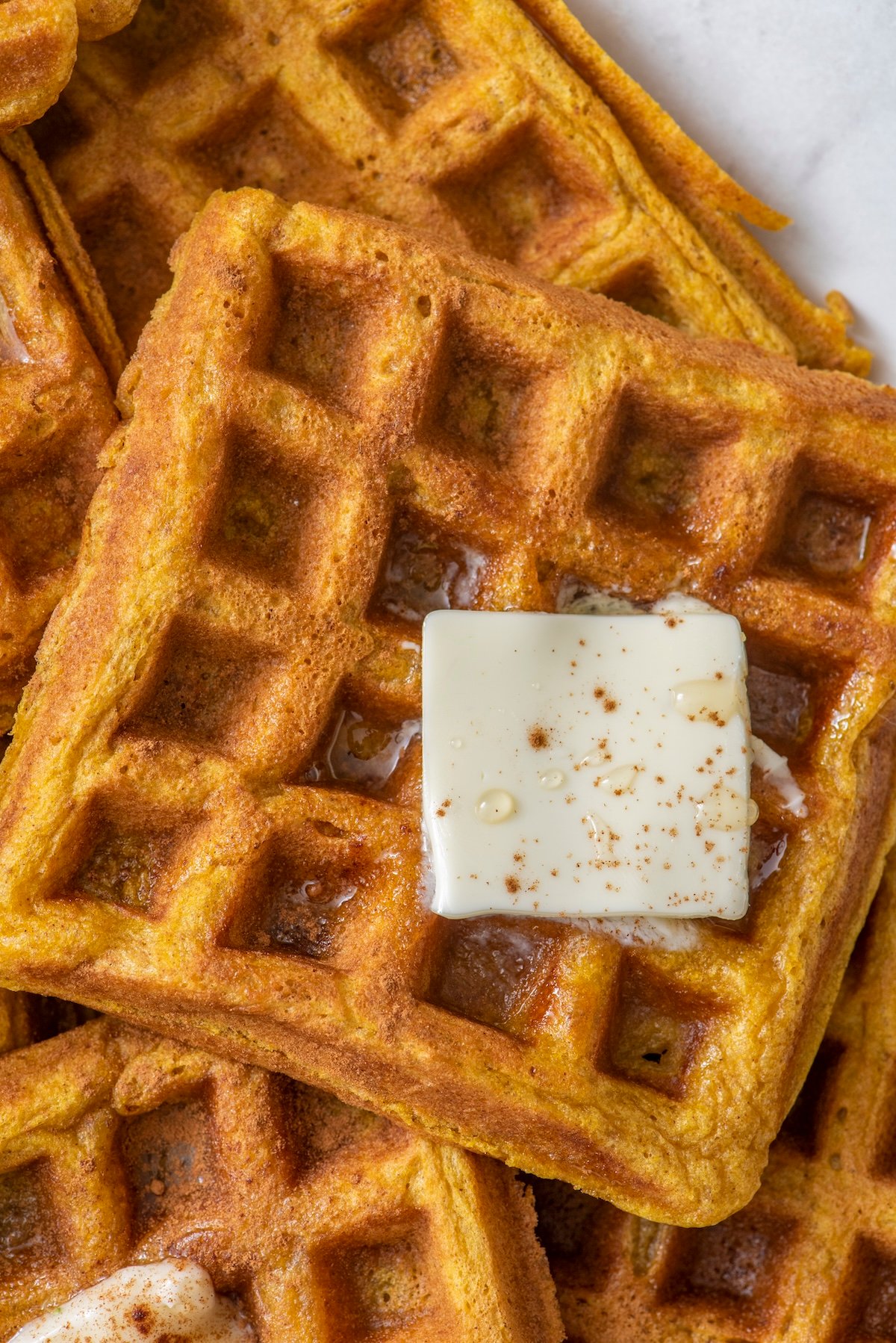 Pumpkin waffles topped with butter.