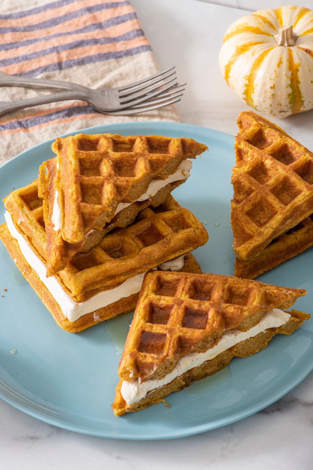 Pumpkin waffle sandwiches on a plate.