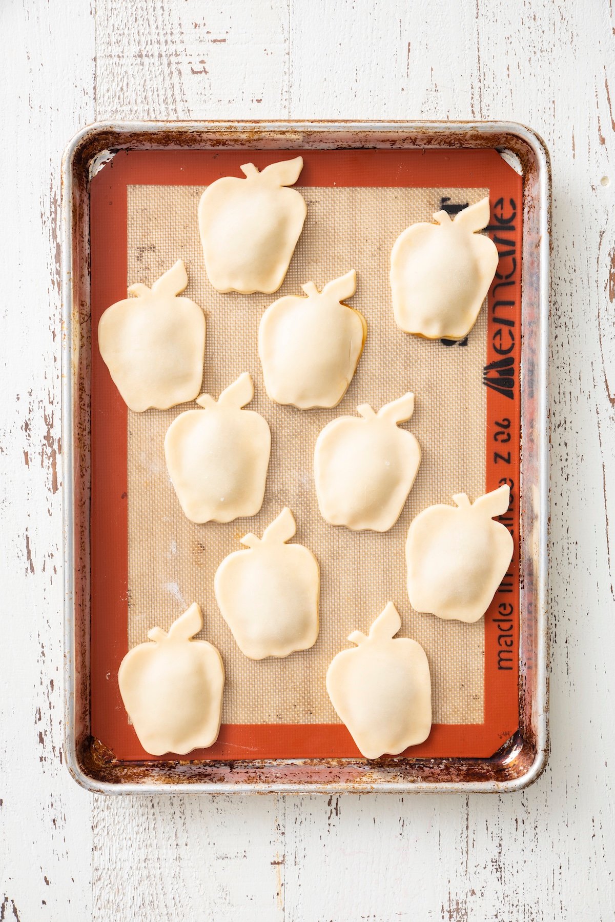 Apple pie turnovers on a baking sheet ready to go in the oven.