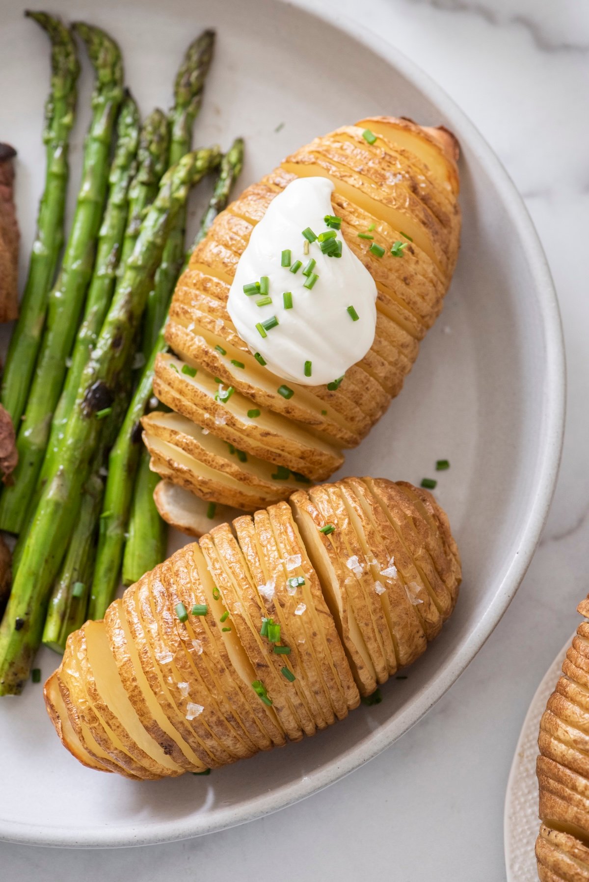 Crispy hasselback potatoes on a plate.