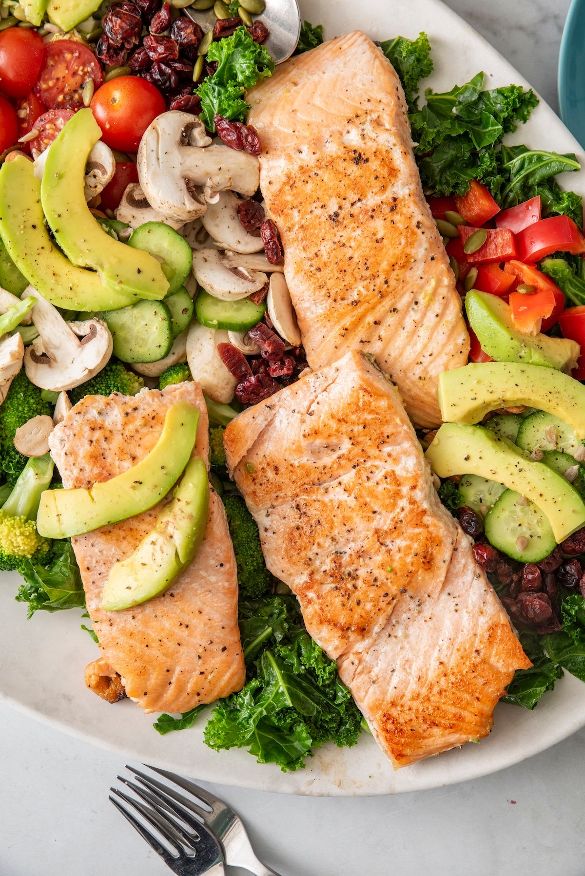 Broiled salmon on top of a superfood salad.