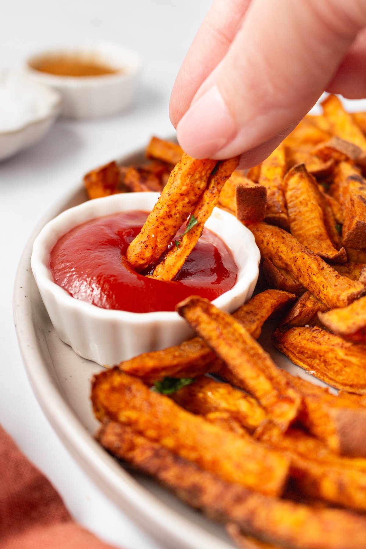 Dipping a sweet potato fry in ketchup.