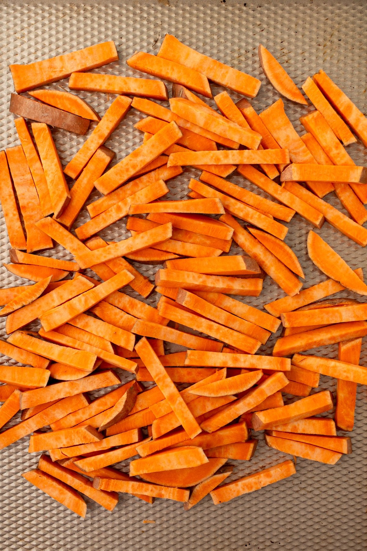 Cut sweet potato fries on a baking sheet.