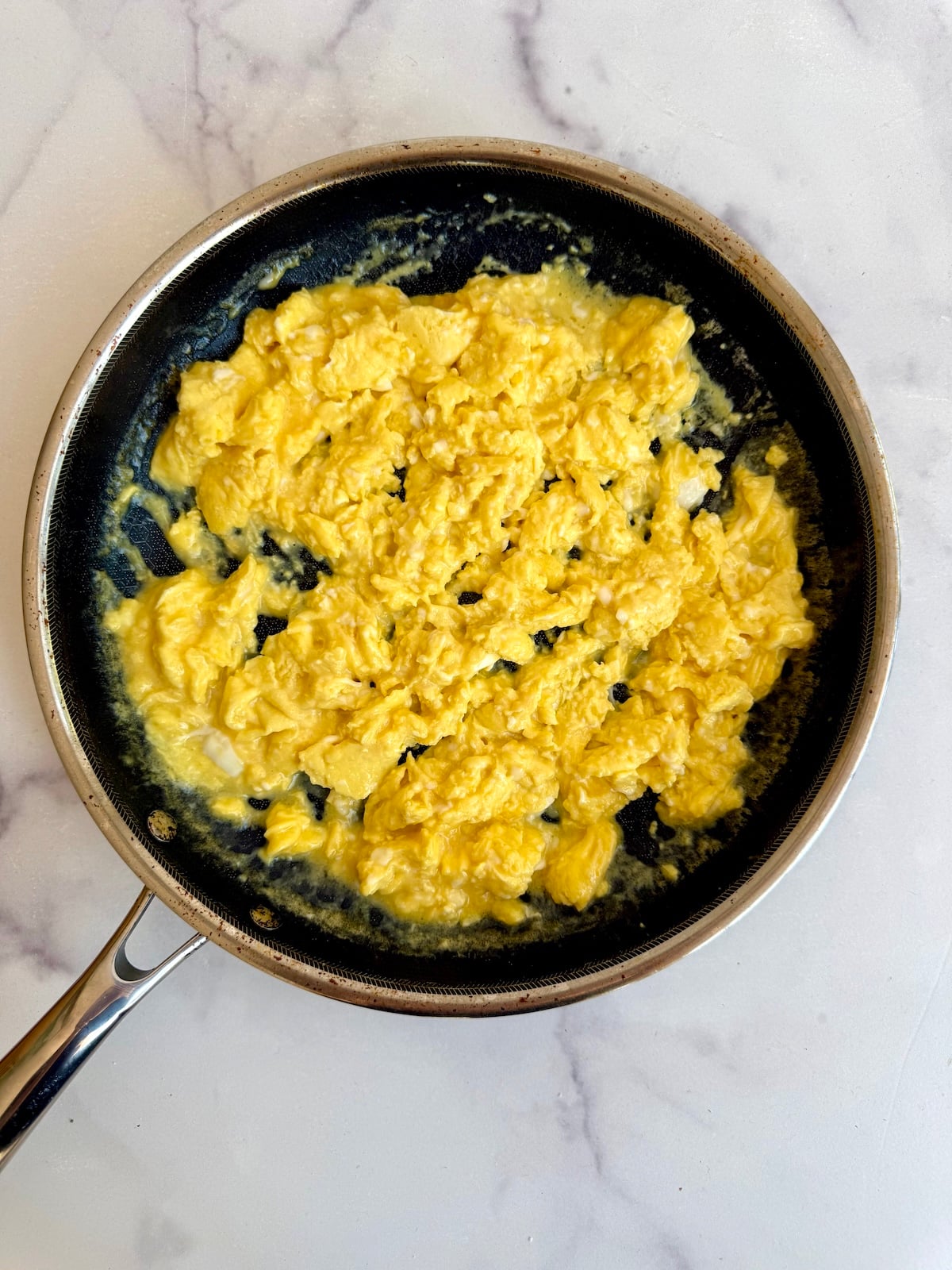 Scrambled eggs in a saute pan.