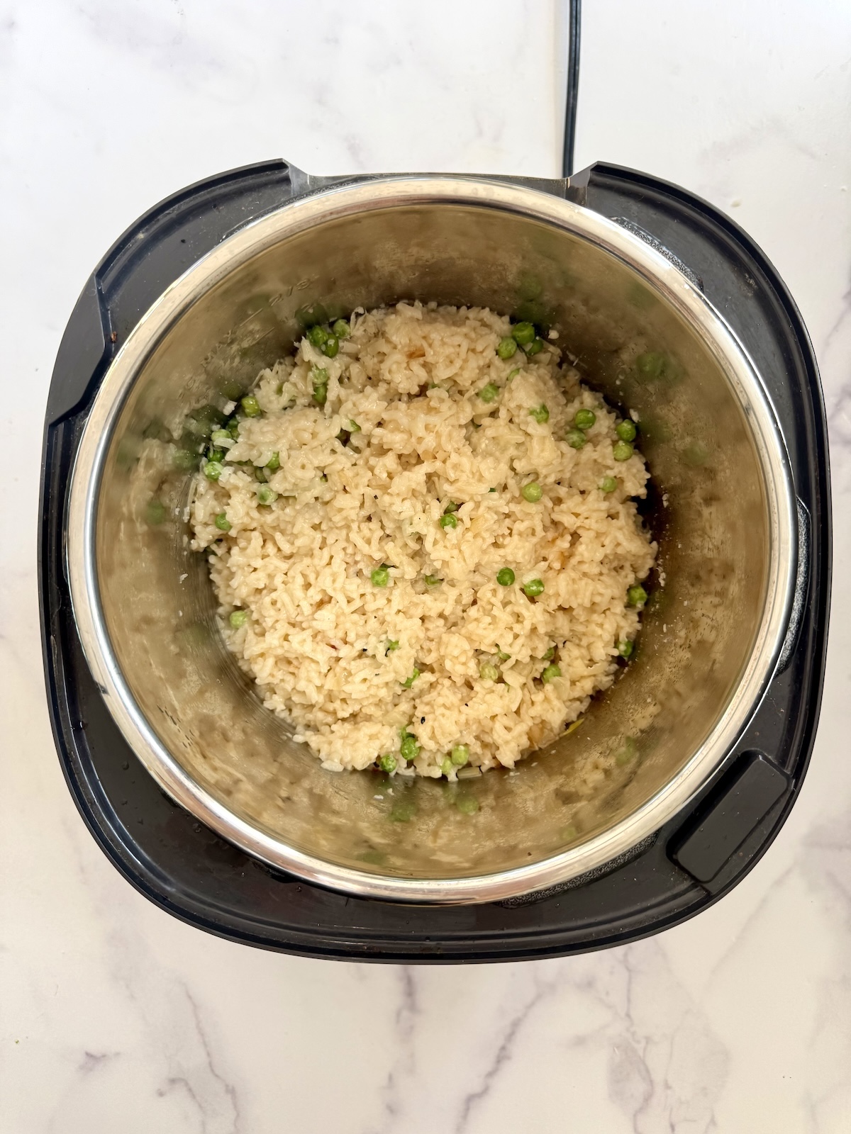 Peas stirred into pressure cooker risotto.