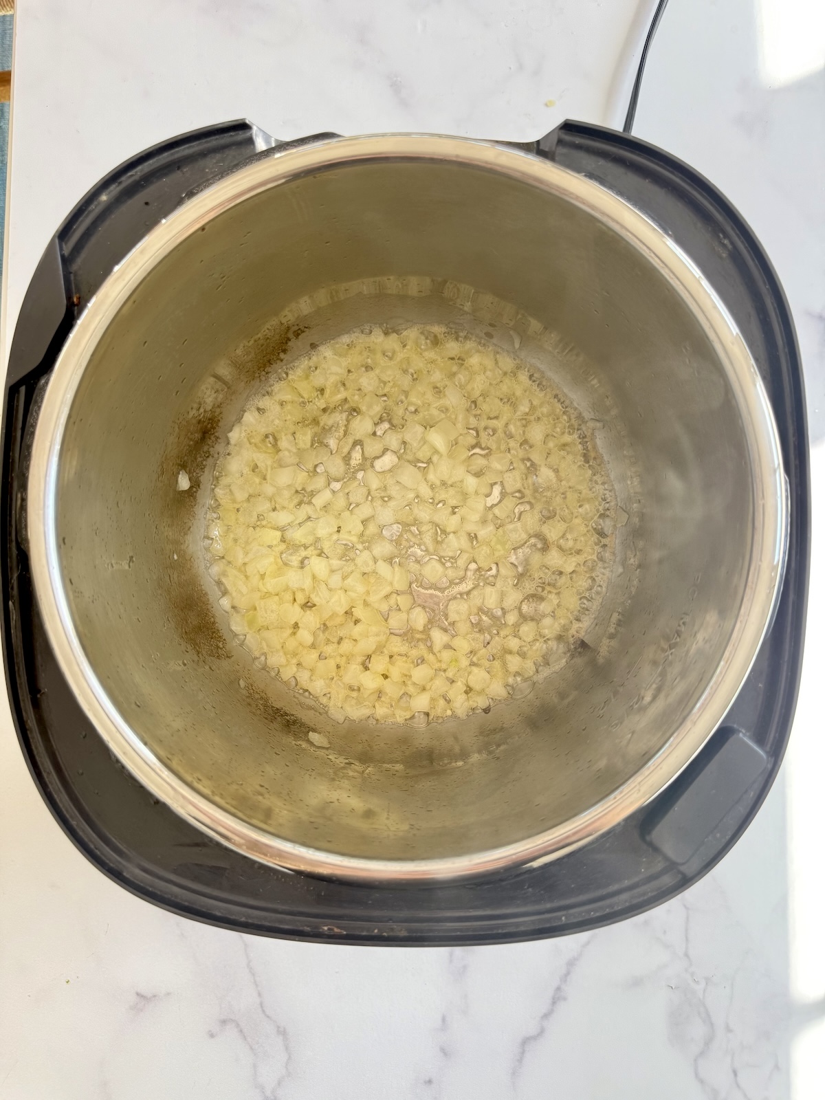 Sauteeing onion in pressure cooker pot.