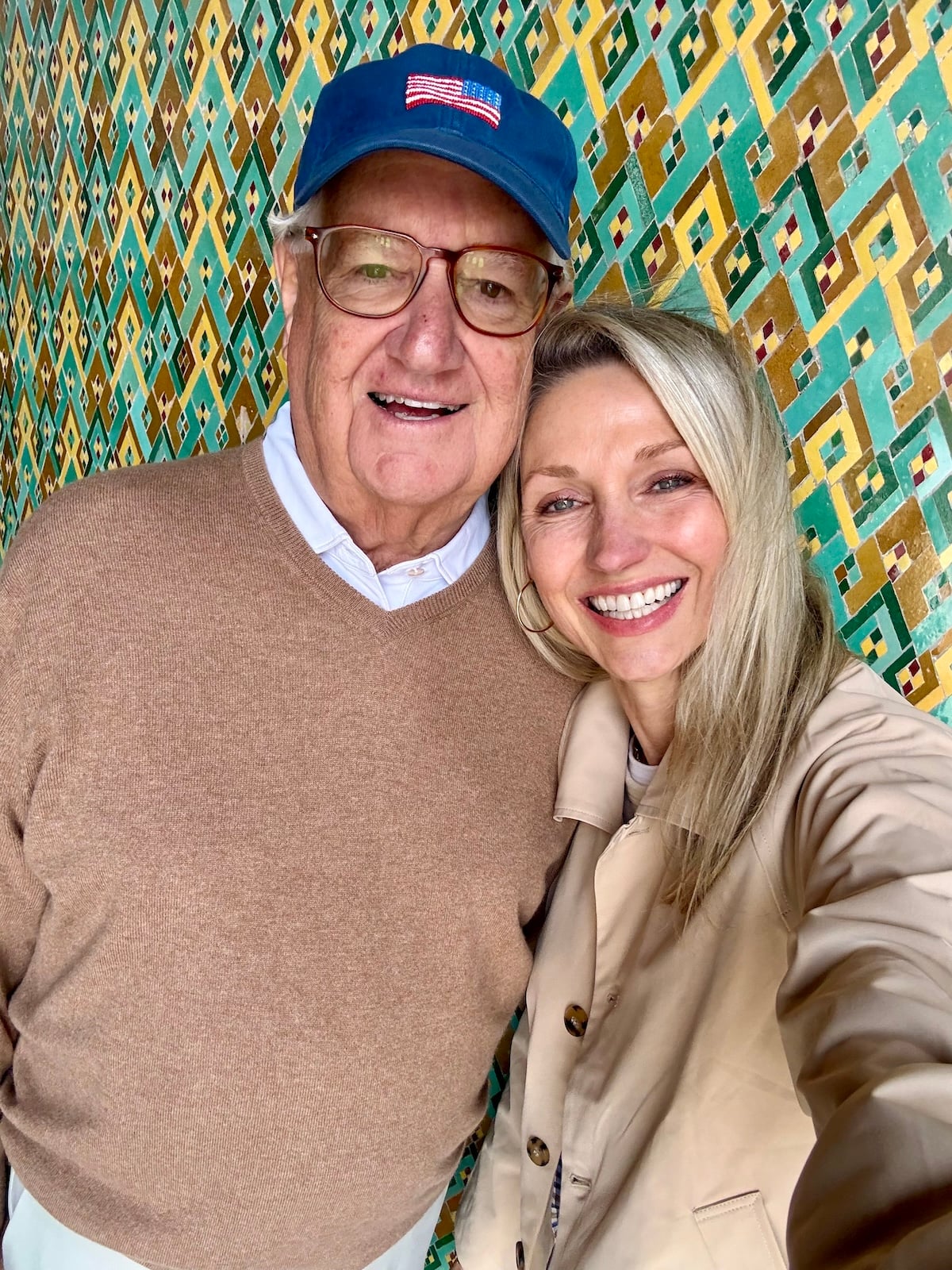 Catherine and her dad taking a selfie together, smiling in front of an intricate geometric tile wall.