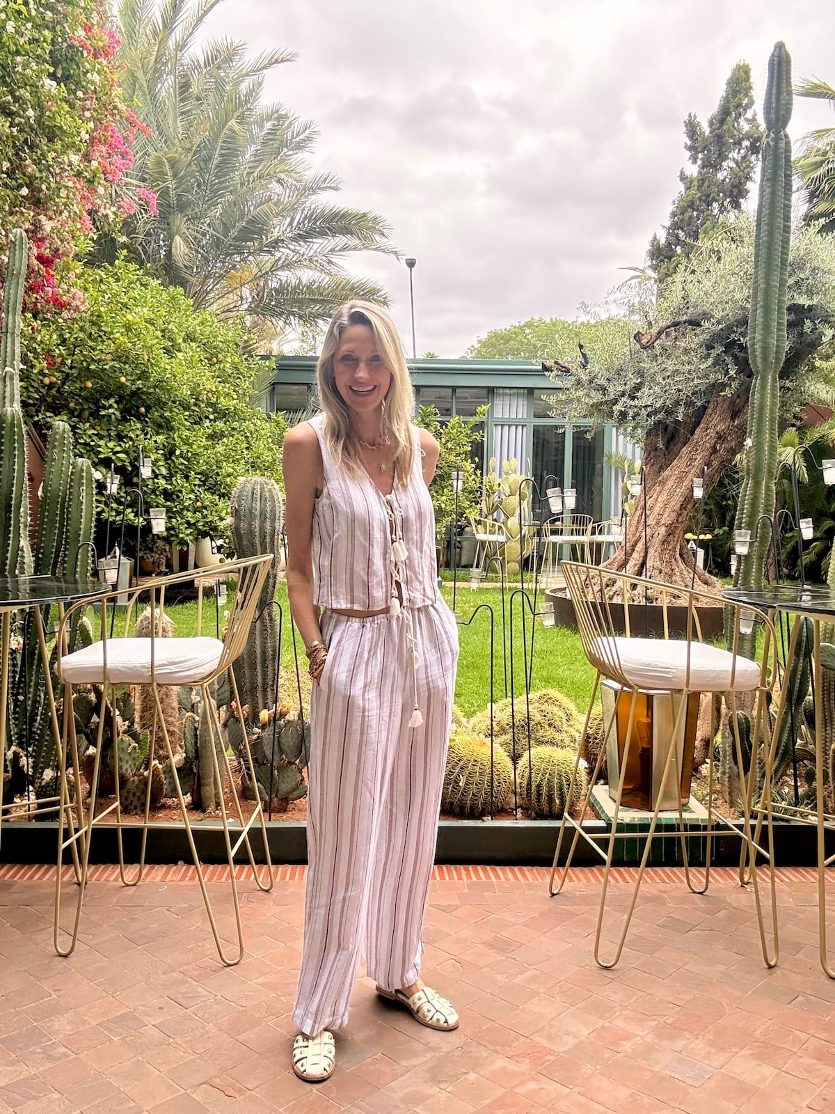 Catherine in a light outfit in a Moroccan riad garden.