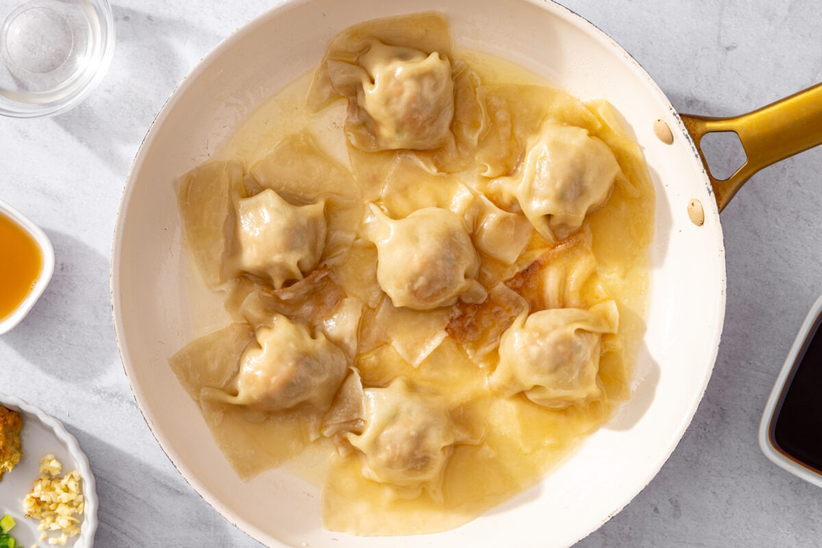 Cooked blanket dumplings in a skillet after steaming.